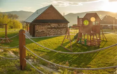 a small playground with a house and a swing at Awesome Home In Slopnice With Sauna in Słopnice