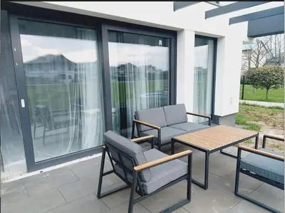 a patio with two chairs and a table on a balcony at Przestronny apartament, ogródek, bezpłatne miejsca postojowe w garażu, AWG APARTMENTS in Kraków