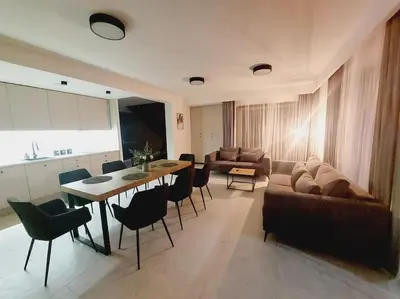 a living room with a couch and a table and chairs at Przestronny apartament, ogródek, bezpłatne miejsca postojowe w garażu, AWG APARTMENTS in Kraków