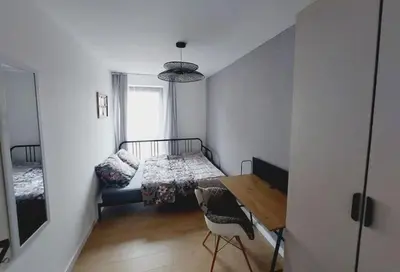 a bedroom with a bed and a table and a chair at Przestronny apartament, ogródek, bezpłatne miejsca postojowe w garażu, AWG APARTMENTS in Kraków