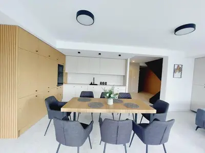 a dining room and kitchen with a table and chairs at Przestronny apartament, ogródek, bezpłatne miejsca postojowe w garażu, AWG APARTMENTS in Kraków