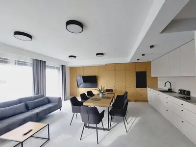 a living room with a couch and a table and chairs at Przestronny apartament, ogródek, bezpłatne miejsca postojowe w garażu, AWG APARTMENTS in Kraków