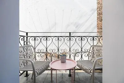 a table and chairs on a balcony with a table at Spacious & Modern 6 Bedroom Apartment - Around The Main Market Square - by Upstairs in Kraków