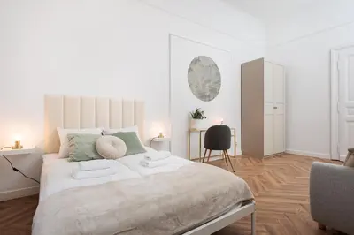 a white bedroom with a large bed and a chair at Spacious & Modern 6 Bedroom Apartment - Around The Main Market Square - by Upstairs in Kraków