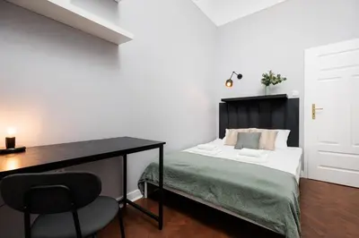a bedroom with a bed with a desk and a chair at Spacious & Modern 6 Bedroom Apartment - Around The Main Market Square - by Upstairs in Kraków