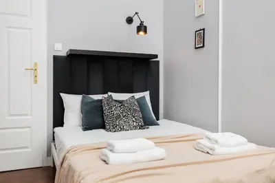 a bedroom with a bed with two towels on it at Spacious & Modern 6 Bedroom Apartment - Around The Main Market Square - by Upstairs in Kraków