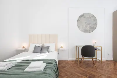 a white bedroom with a large bed and a chair at Spacious & Modern 6 Bedroom Apartment - Around The Main Market Square - by Upstairs in Kraków
