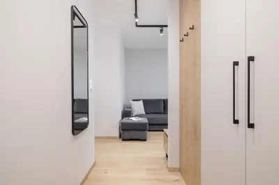 a living room with a couch and a mirror at Lema 19 Uniqe Apartment in Krakow with Garden Air Conditioning Parking near Tauron Arena by Renters Prestige in Kraków