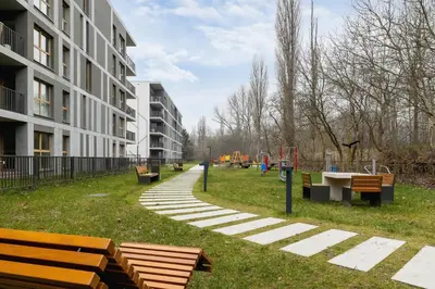 a park with benches and a playground next to a building at Lema 19 Uniqe Apartment in Krakow with Garden Air Conditioning Parking near Tauron Arena by Renters Prestige in Kraków