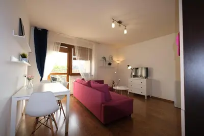 a living room with a red couch and a table at Przystań Dolnych Młynów in Kraków