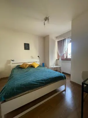 a bedroom with a bed with a green comforter and a window at Przystań Dolnych Młynów in Kraków