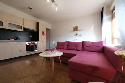 a living room with a purple couch and a table at Przystań Dolnych Młynów in Kraków
