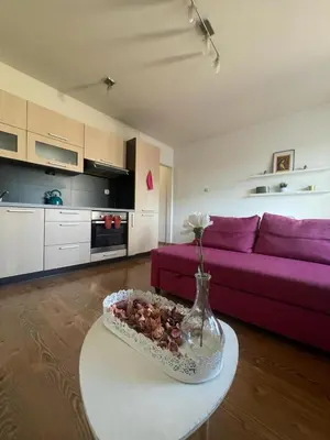 a living room with a purple couch and a table at Przystań Dolnych Młynów in Kraków