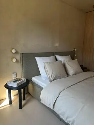 a bed with white pillows and a side table at Tu - Lum Apartament in Kraków