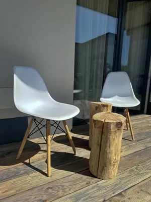 two white chairs sitting on top of a wooden floor at Tu - Lum Apartament in Kraków