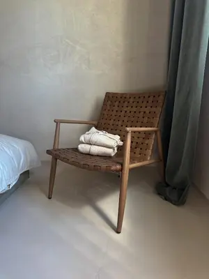 a wooden chair with towels on it next to a bed at Tu - Lum Apartament in Kraków
