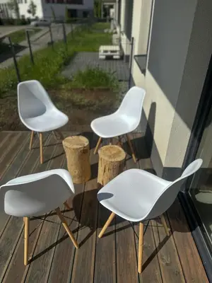three chairs and tables on a porch with a window at Tu - Lum Apartament in Kraków