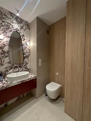 a bathroom with a toilet and a sink and a mirror at Tu - Lum Apartament in Kraków