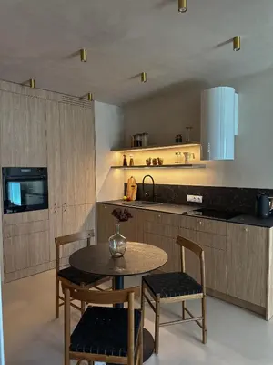 a kitchen with a table and chairs and a counter at Tu - Lum Apartament in Kraków