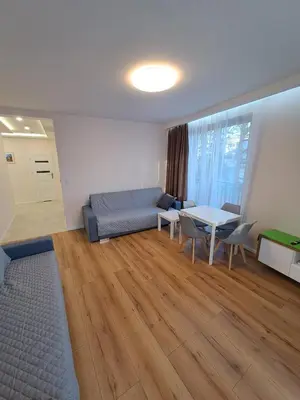 a living room with a couch and a table at APARTAMENTY HEMMA ORAWSKA 14 in Kraków