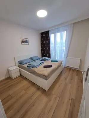 a bedroom with a bed and a wooden floor at APARTAMENTY HEMMA ORAWSKA 14 in Kraków