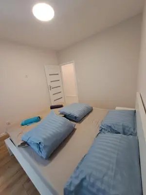 a bedroom with two beds with blue pillows at APARTAMENTY HEMMA ORAWSKA 14 in Kraków