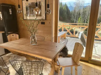 a wooden table with chairs and a vase with flowers at Babiogórskie klimaty in Zawoja