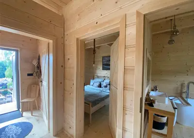 a wooden cabin with a bed and a sink at Babiogórskie klimaty in Zawoja