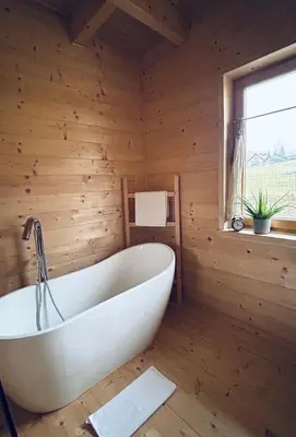 a bath tub in a room with a wooden wall at Babiogórskie klimaty in Zawoja