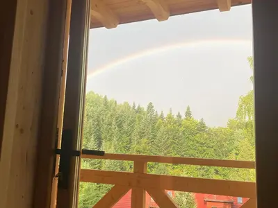 a view of a rainbow from a window at Babiogórskie klimaty in Zawoja