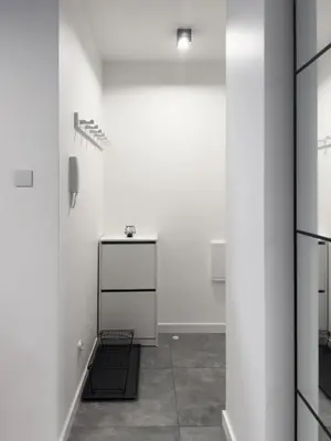 an empty room with a white wall and a phone at Industro Art Zablocie - Balcony - WiFi 1GB - 55