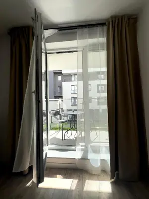 a sliding glass door to a balcony with a table at Industro Art Zablocie - Balcony - WiFi 1GB - 55