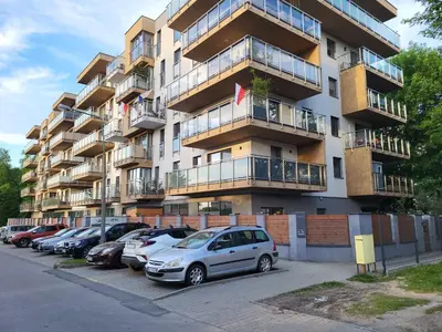 a large apartment building with cars parked in a parking lot at Apartament DeLuxe 4 in Oświęcim