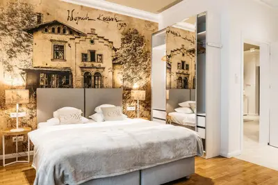 a bedroom with a large bed and a wall with a building at AVANTI Home in Kraków