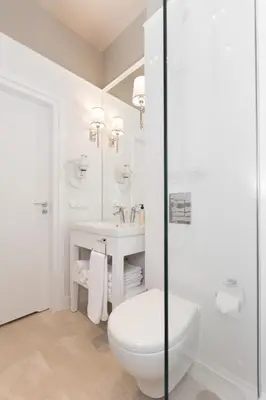 a white bathroom with a toilet and a sink at AVANTI Home in Kraków