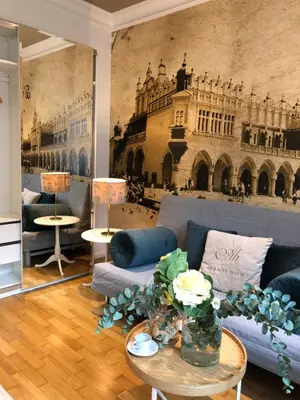 a living room with a blue couch and a mural of a building at AVANTI Home in Kraków