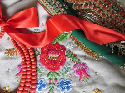 a close up of a quilt with red ribbon and flowers at AVANTI Home in Kraków