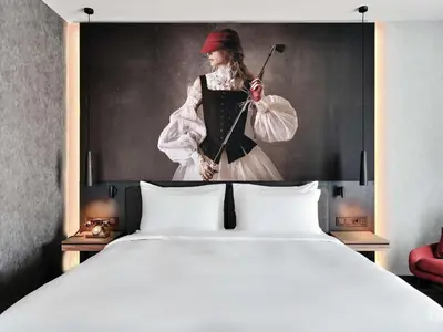 a hotel room with a bed and a desk and a window at Radisson RED Hotel & Radisson RED Apartments, Kraków in Kraków