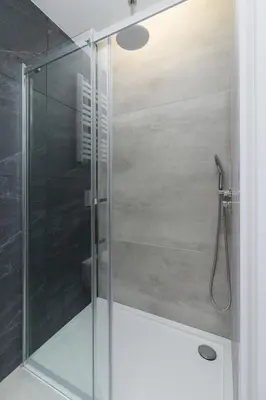 a shower with a glass door in a bathroom at Kazimierz Area - Dietla 21 street in Kraków