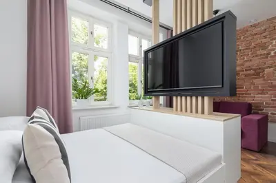 a living room with a flat screen tv on a brick wall at Kazimierz Area - Dietla 21 street in Kraków