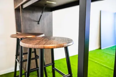 two bar stools in a room with green grass at Dom na Białych Brzóz pod Krakowem in Zabierzów