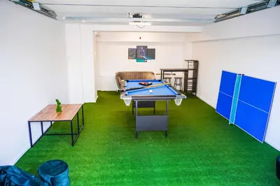 a room with a ping pong table and green carpet at Dom na Białych Brzóz pod Krakowem in Zabierzów