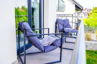a pair of purple chairs sitting on a porch at Dom na Białych Brzóz pod Krakowem in Zabierzów