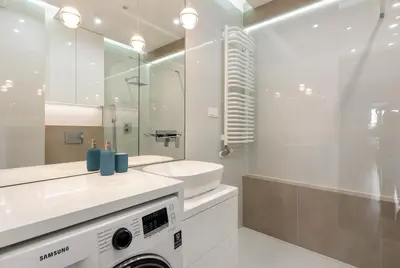 a bathroom with a sink and a washing machine at ROYAL Deluxe 2 rooms 6 persons Aquapark Down Town in Kraków