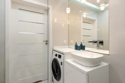 a white bathroom with a washing machine and a sink at ROYAL Deluxe 2 rooms 6 persons Aquapark Down Town in Kraków