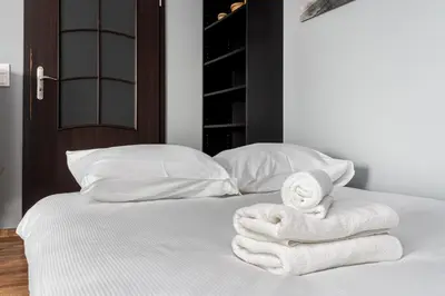 a bed with white towels on top of it at Podgórze Standard Studio by BookingHost in Kraków