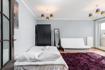 a bedroom with a white bed and a purple rug at Podgórze Standard Studio by BookingHost in Kraków