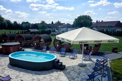 a patio with an umbrella and a hot tub at Fantazja Resort Zator in Zator