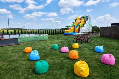 a group of inflatable chairs in the grass with a playground at Fantazja Resort Zator in Zator