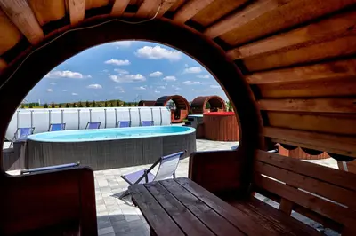 an archway in a wooden building with a swimming pool at Fantazja Resort Zator in Zator